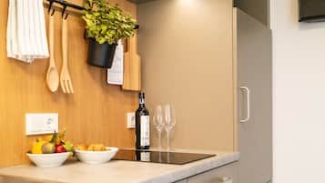 Una cocina moderna con encimera de mármol, una botella de vino y un frutero.
