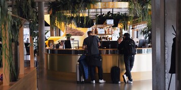 Un área de recepción con mostrador, un cartel que dice “RECEPTION” y un cartel que indica “HOTEL FOOD & DRINKS.”