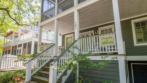 A multi-story building with a porch, a sign reading "Changes in Attitudes," and a staircase leading to the entrance. - Massive Beachwalk Resort Home with Lake Views (Michigan City)