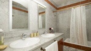 Une salle de bain avec deux lavabos, un grand miroir et un rideau de douche.