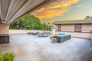 An outdoor patio with a table and chairs, a sofa, and a decorative basket.