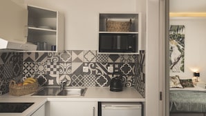 A compact kitchen with a microwave, kettle, and a basket of fruit. - Casa Maria (Zakynthos)