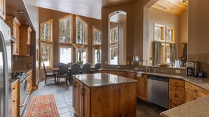 Une cuisine spacieuse avec des meubles en bois, un plan de travail en granit et un grand îlot central.