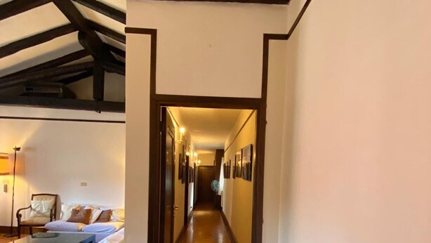 Un couloir avec un plancher en bois, un canapé et une table sur le côté gauche.