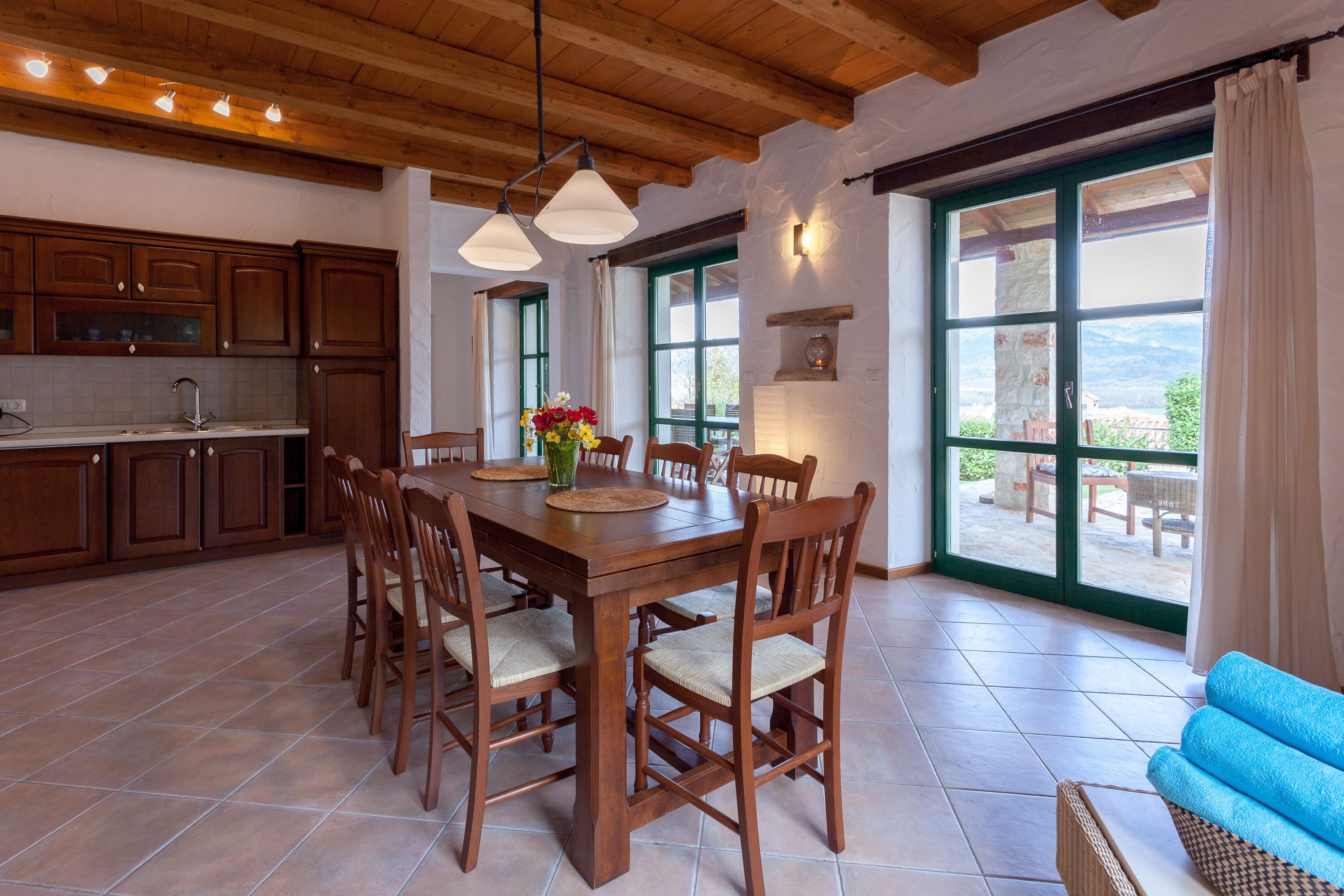 A spacious kitchen with wooden cabinets and a dining table surrounded by chairs.