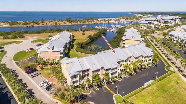 A hotel with a parking lot, a marina, and a view of the ocean.