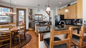 Cocina moderna con armarios de madera, una isla central e iluminación colgante.