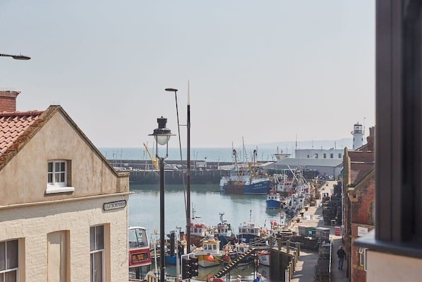 A harbor with boats docked, a lighthouse in the background, and a building labeled "Eastborough." - Host & Stay | Othala @ The Merchants Quarters (Scarborough)