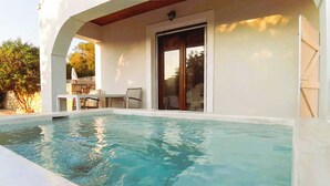 Une piscine à eau claire avec un patio couvert, une table et des chaises.