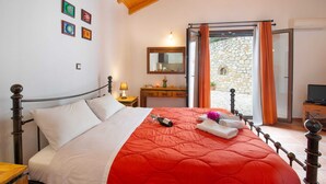 Une chambre à coucher comprenant un lit, une table de chevet, une commode, un miroir et un téléviseur.