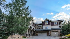 A two-story house with a garage, a driveway, and a stone sign with the name 'Riverbend' and address. - Riverbend Snowflake Run Condo: At Snowflake Lift (Breckenridge)