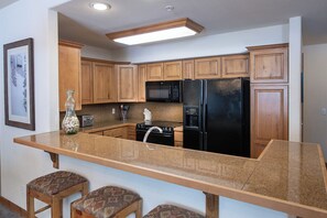 Enjoy cooking in this well-equipped kitchen with a central island, stainless steel appliances, and ample cabinetry.
