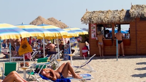 A beach with sun loungers, umbrellas, and a wooden hut. - Hotel Europeo (Chioggia)