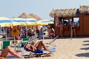 Een privéstrand, wit zand, parasols, beachvolleybal