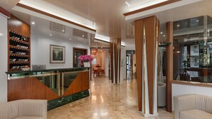 A hotel lobby with a reception desk, seating area, and a bar. - Hotel Europeo (Chioggia)
