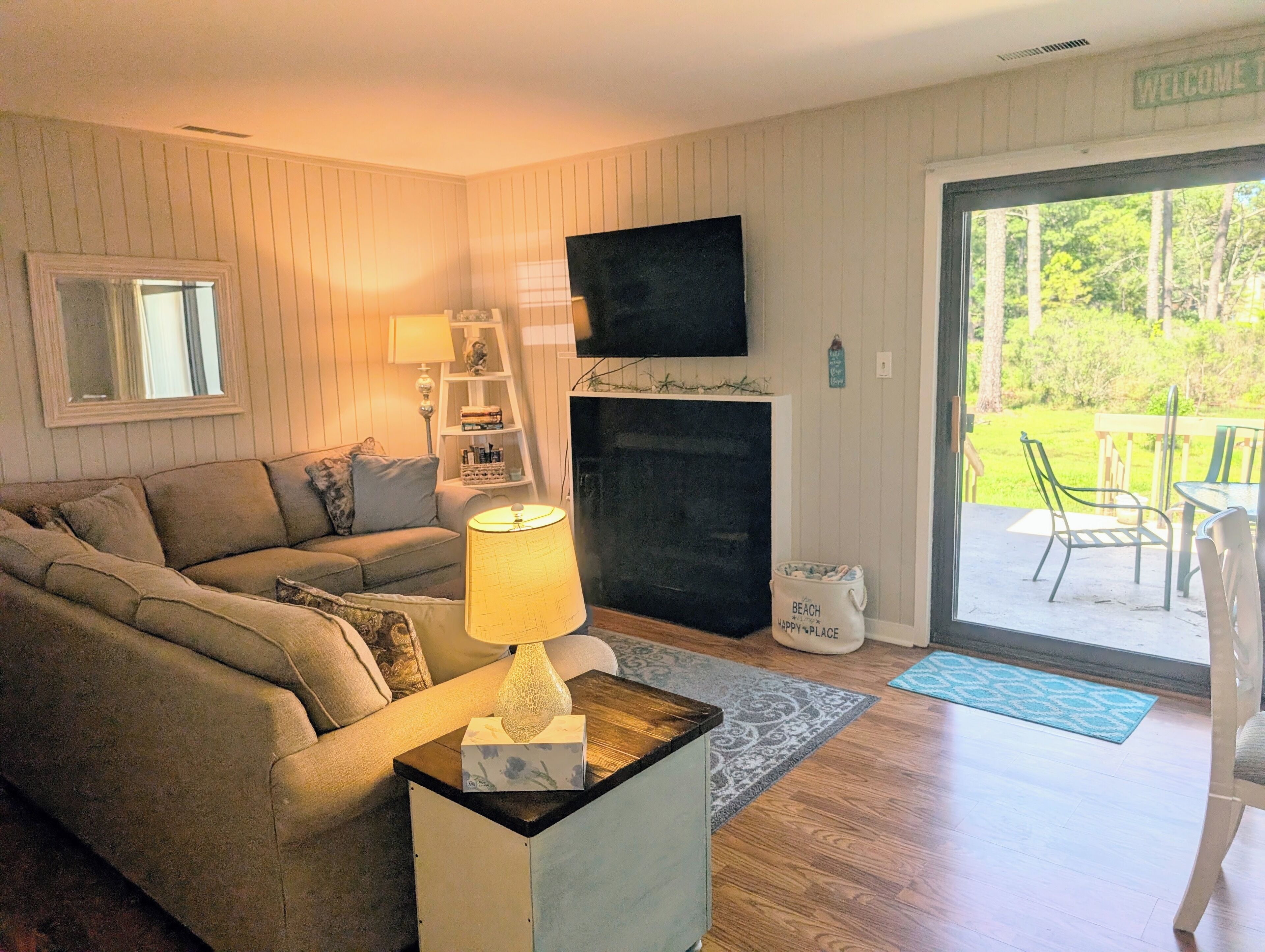 A living room with a sofa, a lamp, a TV, and a fireplace.