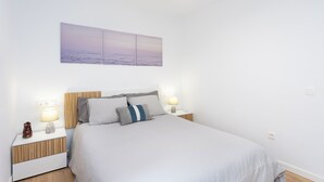 Una camera da letto con un letto, due comodini, una lampada da notte e un'opera d'arte appesa al muro.