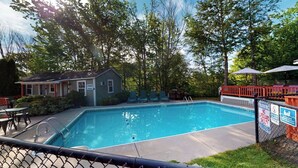 A swimming pool with a fenced deck, lounge chairs, and a small building labeled 'Swimming Pool.' - The Lakeview Cottage 9 (Laconia)