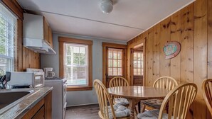 A kitchen with a microwave, toaster, and sink, wooden dining table with chairs, and a sign that says 'EAT HERE'. - The Lakeview Cottage 9 (Laconia)