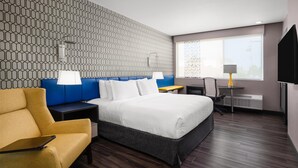 Een hotelkamer met een bed, een bureau, een stoel en een televisie.