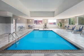 Una piscina techada, sillones reclinables de piscina