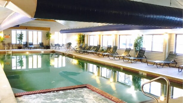 An indoor swimming pool with lounge chairs and a hot tub area. - Nice Condo At Attitash Mountain Village, Close to Storyland, Location! (Bartlett)