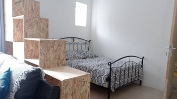 Un dormitorio con una cama, un escritorio y una silla. Hay una ventana que ofrece vistas al exterior.