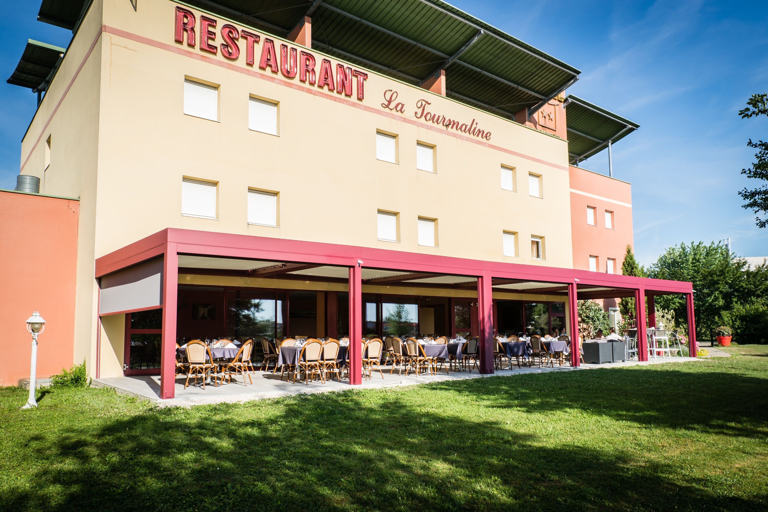 Un restaurante con terraza al aire libre, un patio cubierto y un letrero que dice "RESTAURANT La Tournaline".