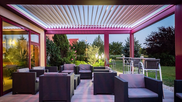 An outdoor patio with wicker furniture and a pergola.