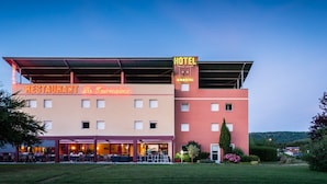 A hotel with a restaurant named "La Tournmaine" on the ground floor, featuring outdoor seating.
