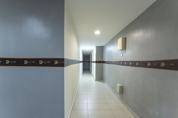 A hallway with a tiled floor and walls painted in two colors.