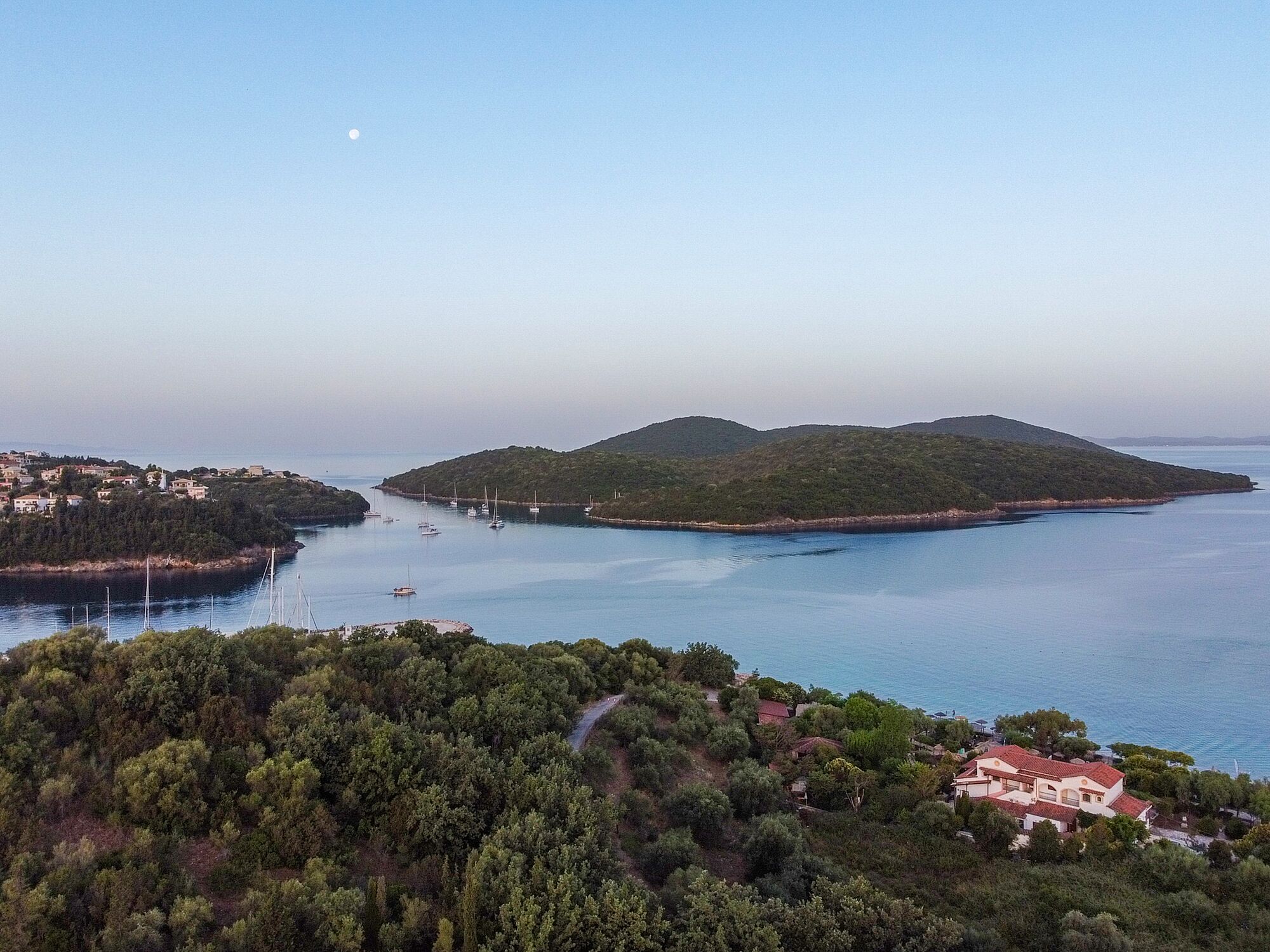 A coastal landscape with a small island, clear sky, and calm sea.