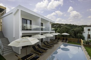 Una piscina al aire libre de temporada, sombrillas