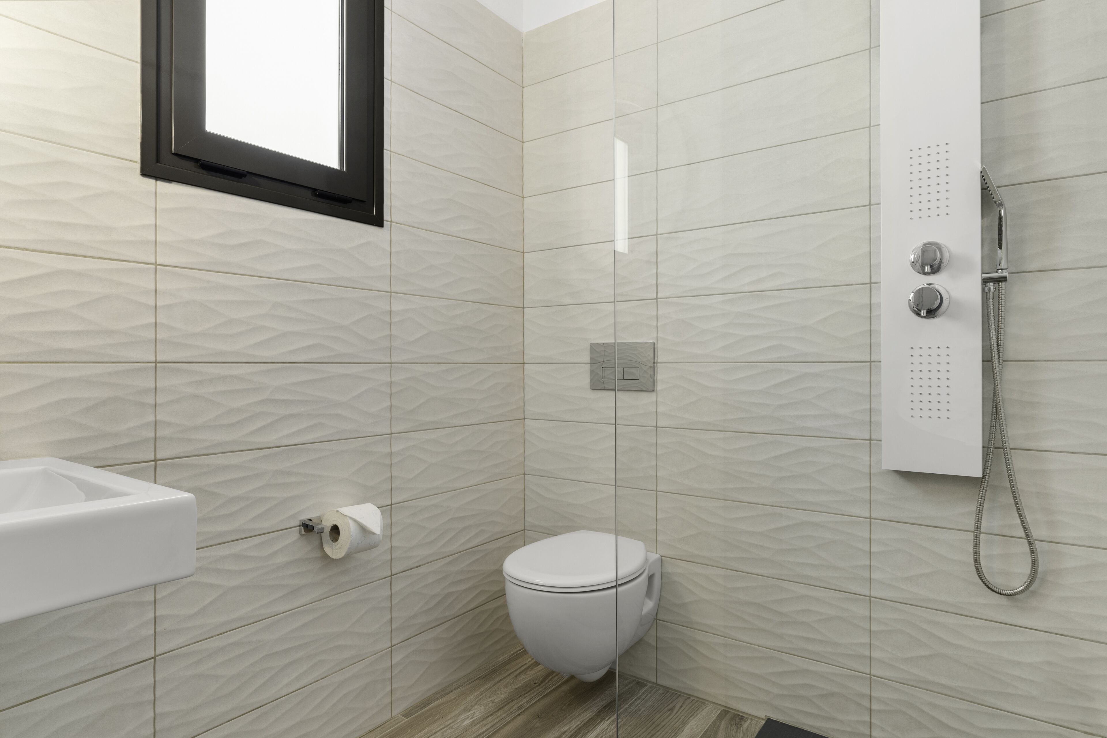 A modern bathroom with a toilet, a sink, and a shower.