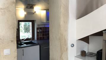 A kitchen with a modern design, featuring a built-in oven, a sink, and a countertop with a toaster.