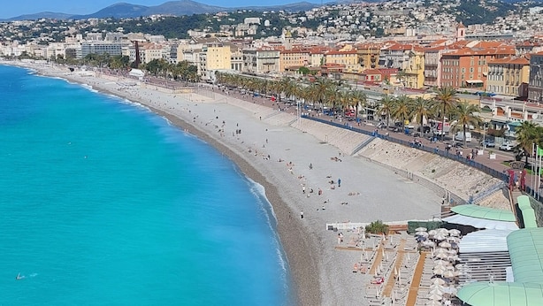 A coastal cityscape with a beach, buildings, and a clear blue sky. - Old Town Nice Family APT  Spacious  2BR;  A/C  3 min walk Beach cafes shops tram (Nice)