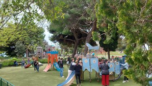 A playground with slides and climbing structures surrounded by trees. - Old Town Nice Family APT  Spacious  2BR;  A/C  3 min walk Beach cafes shops tram (Nice)