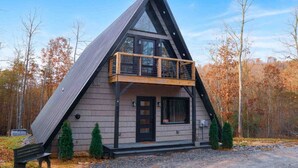 A modern A-frame cabin with a balcony, surrounded by trees. - Ultimate Romantic Couples Getaway in Wine Country (Dobson)