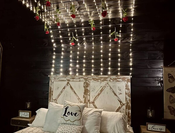 A bedroom with a bed, decorative lights, and a wall with a butterfly pattern.