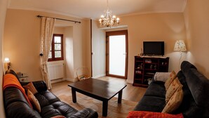 A living room with a sofa, a coffee table, a TV, and a bookshelf. - Vieiro Verde 2 Rustic (Vieiro)