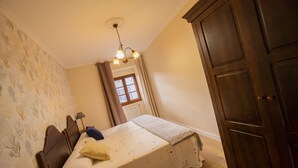 A bedroom with a bed, a wooden wardrobe, and a window with curtains. - Vieiro Verde 2 Rustic (Vieiro)