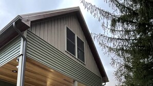 A two-story house with a covered porch and a fenced deck. - Parsons Riverside Retreat: Steps away from a rolling mountain stream and trails (Parsons)