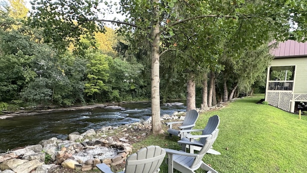 A riverside view with two Adirondack chairs and a small building with a red roof. - Parsons Riverside Retreat: Steps away from a rolling mountain stream and trails (Parsons)
