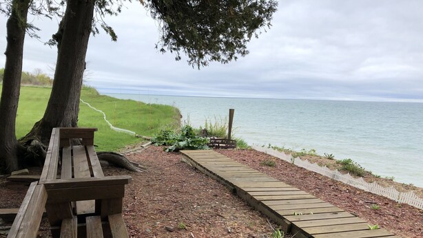 Un banc en bois et une promenade en bois menant à un lac.