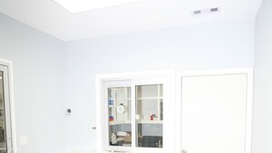 A room with a slanted ceiling, a built-in shelf, a door, and a light-colored floor. - Edna Star Motel & Laundry (Edna)