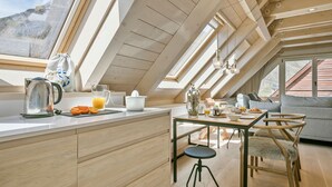 Uma cozinha moderna com claraboias, armários de madeira e um espaço de jantar com mesa e cadeiras.