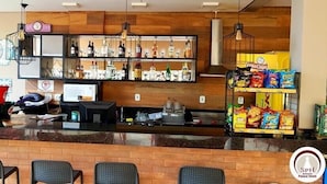A bar area with shelves of bottles, a cash register, and snack dispensers.