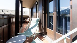 A balcony with a view of snow-capped mountains, a chair, and a table. - Sertorelli 2 - One Bedroom Apartment, Sleeps 3 (Bormio)