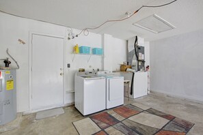 Convenient laundry facilities feature two front-loading washing machines and storage for essentials.