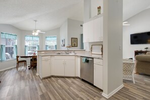 Enjoy cooking in this well-equipped kitchen with a central island, sink, and dishwasher, and dine in the adjacent dining area with a flat-screen TV.
